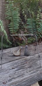 small sculpture of two birds on a swing.